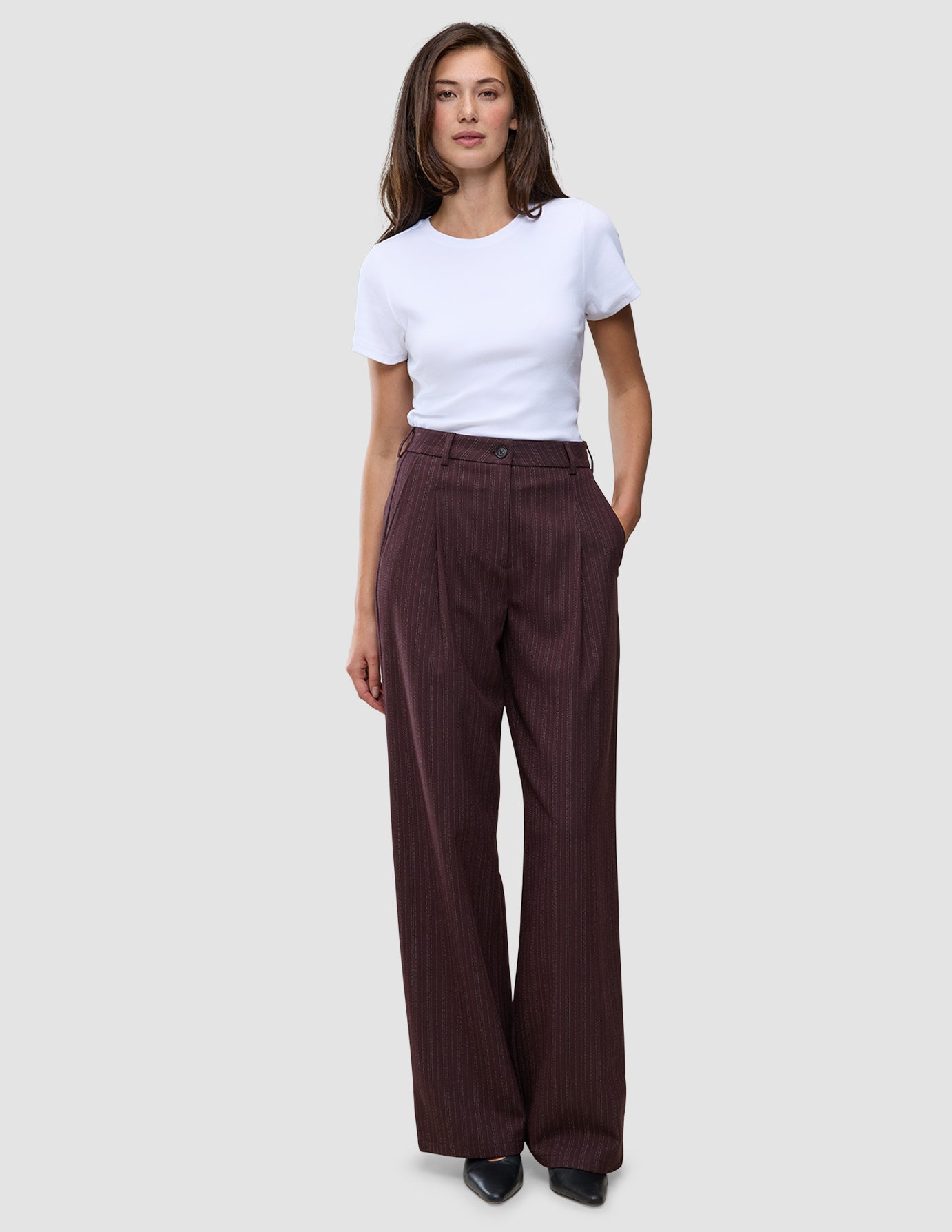 En kvinne i en hvit T-skjorte og Women Serene Pants Wide Berry Pinstripe.